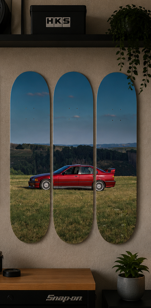 Skateboard decks with a red E36 sports car on a grassy field with blue skies. 