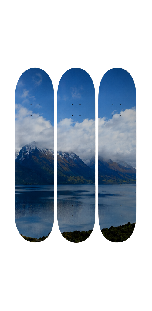 Three skateboard decks with mountain and lake design on a white background